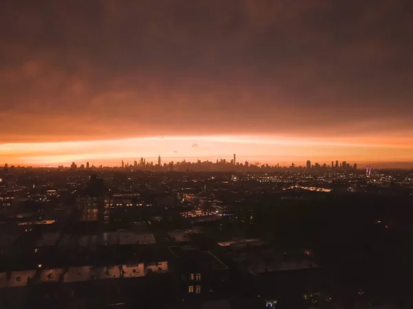 Brooklyn 'den Manhattan' a kadar uzanan hava görüntüsü günbatımından sonra Ateş Kırmızı Işığı ve Gökdelen Silueti ile 