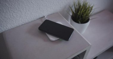 Kablosuz şarj cihazından akıllı telefon alınıyor.