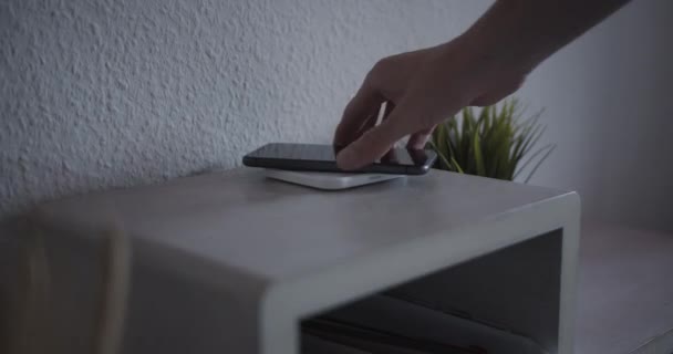 Akıllı telefon pili şarj etmek için kablosuz şarj pedine yerleştiriliyor — Stok video
