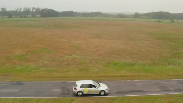 Großaufnahme: Antenne eines Elektrofahrzeugs fährt am nebligen Tag über Straße in deutscher Natur — Stockvideo