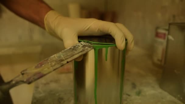 Primer plano del pintor abriendo una lata de color verde — Vídeos de Stock