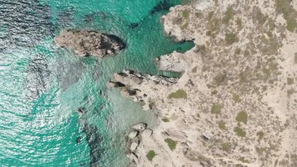Полет сверху вниз над греческим островом Милош бирюзовый голубой океан с Рокки-Клифф Кост — стоковое видео