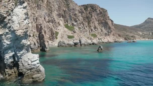 Greek Island Milos 의 Turquoise Blue Ocean Water 의 암석 분출물 사이의 느린 돌리 항공 — 비디오