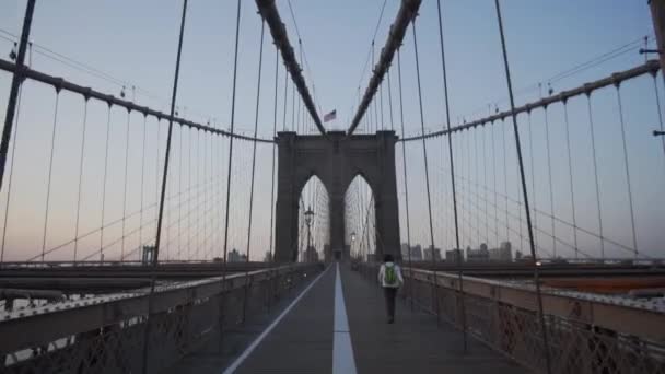 SLOW MOTION: Brooklyn Bridge with Woman walking early morning at sunrise in beautiful sunlight in summer — Stock Video