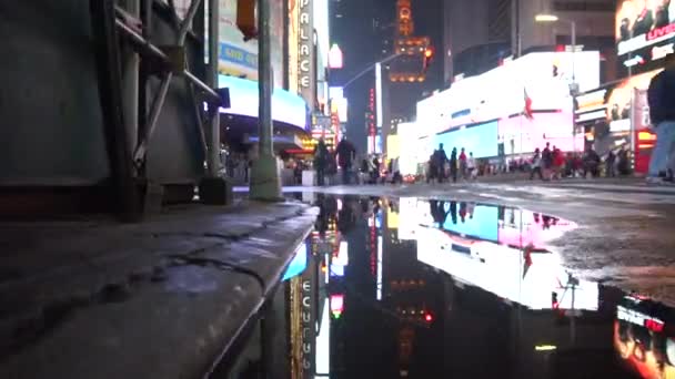 Times Square Światła odbijają się w kałuży po deszczu w Nowym Jorku w nocy Manhattan — Wideo stockowe