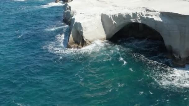 Luchtfoto van Sarakiniko maanvulkanisch strand met golven die tegen rotsen botsen in Milos, Griekenland — Stockvideo