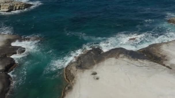 Blick aus der Vogelperspektive auf Ozeanwellen, die auf weiße Felsen in Griechenland stürzen — Stockvideo