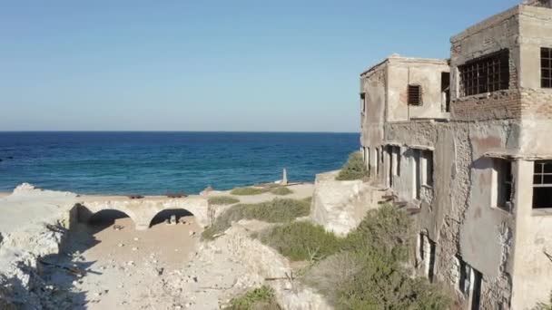 Yunanistan 'ın Milos Adası sahilindeki Eski Terk Edilmiş Fabrika Binası boyunca Aerial Dolly — Stok video