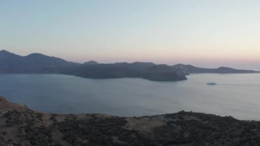 Günbatımında Yunanistan 'daki adalardan geçen bir yolcu gemisi