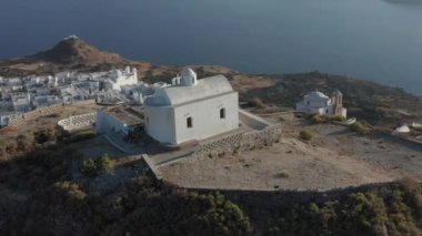 Tepenin tepesinde Yunan Bayrağı rüzgarda dalgalanırken kilise