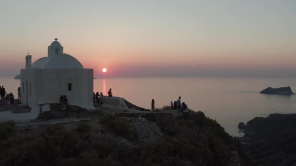 Touristen genießen den Sonnenuntergang vom Aussichtspunkt der Kirche über der Insel in Griechenland — Stockvideo