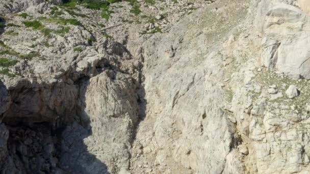 AERIAL: Guy står på kanten av Cliff med blå vatten vågor krossar på Tropical Island Mallorca, Spanien Semester, Resor, Soligt, Vågor — Stockvideo