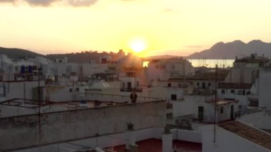 Little Townhouse 'un çatısında dikilen adam Tropikal Ada Limanı ile Sunrise' da botları ve okyanusu olan arka planda dağları olan seyahat, günbatımında gezen adam. 