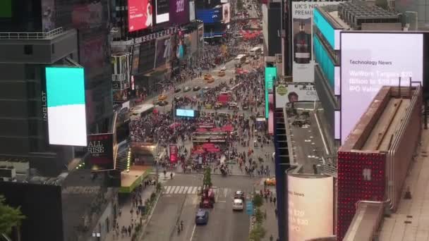 AERIAL: Look over Times Square heart of New York City at Daylight with crowd of people and heavy car traffic advertisements and police — Stock Video