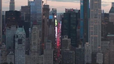 Sunset 'teki New York City Central Park' taki trafik ve Times Meydanı 'nın üzerinde şehir ışıklarıyla