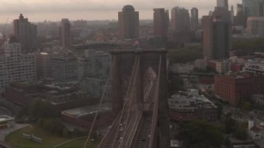 Brooklyn Köprüsü üzerinde sabah güneşiyle Brooklyn 'e doğru hareket eden bir araba trafiği var. 