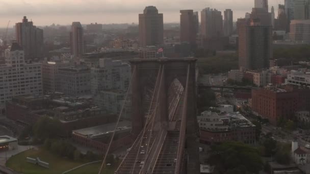 AERIAL: Flight over Brooklyn Bridge with moving car traffic sunrise morning light towards brooklyn — Stock Video
