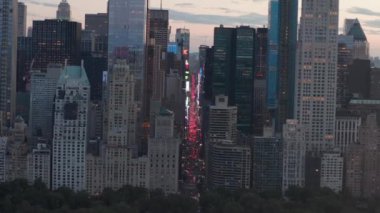 Sunset 'teki New York City Central Park' taki trafik ve Times Meydanı 'nın üzerinde şehir ışıklarıyla