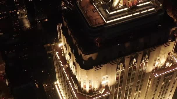 AERIAL: Breathtaking circle over the iconic Empire State Building above lit up parallel avenues and junctions residential condominiums and office buildings in Midtown Manhattan, New York City at night — Stock Video