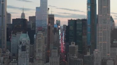 Sunset 'teki New York City Central Park' taki trafik ve Times Meydanı 'nın üzerinde şehir ışıklarıyla