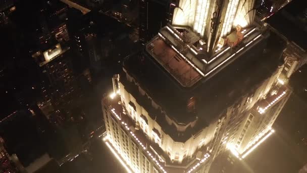 Захватывающий дух круг над культовым Эмпайр-стейт-билдинг выше освещал параллельные проспекты и перекрестки жилых кондоминиумов и офисных зданий в центре Манхэттена, Нью-Йорк ночью — стоковое видео