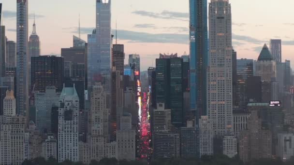 एअरियल: सिटी लाइट्ससह सनसेट येथे न्यूयॉर्क सिटी सेंट्रल पार्कवर 7th व्या अव्हेन्यू वाहतूक आणि टाइम्स स्क्वेअरचा दृश्य — स्टॉक व्हिडिओ