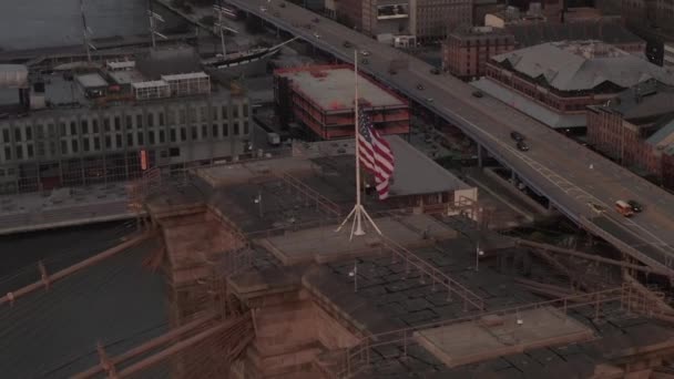 Blízký kruhový let nad Brooklynským mostem s americkou vlajkou a mlhavým Manhattanem New York City Skyline — Stock video