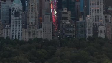 Sunset 'teki New York City Central Park' taki trafik ve Times Meydanı 'nın üzerinde şehir ışıklarıyla