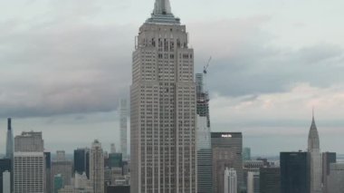 Manhattan 'daki Empire State binasında bulutlu bir günde kalabalık bir şehirde gökdelenlerle çevriliyken... 