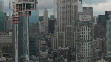 Manhattan 'daki Empire State binasında bulutlu bir günde kalabalık bir şehirde gökdelenlerle çevriliyken... 
