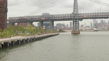 Bulutlu bir günde New York 'ta Williamsburg Köprüsü' ne doğru uçuş. 