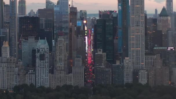 AERIAL: View of 7th Avenue Traffic and Times Square over New York City Central Park at Sunset with City lights — Stock Video