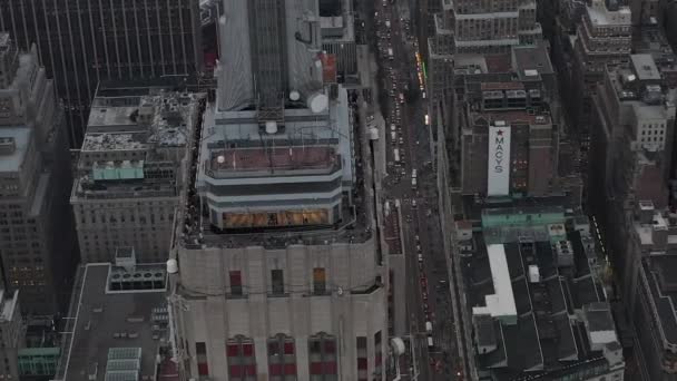 AERIAL: Beautiful shot circling the Empire State building in manhattan surrounded by skyscrapers in busy City at cloudy day — Stock Video