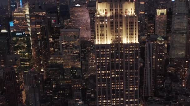 AERIAL: Blick auf das wunderschöne Manhattan bei Nacht, umgeben von Wolkenkratzern in der geschäftigen City in — Stockvideo