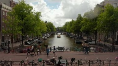 Amsterdam Kanal Köprüsü 'nde maskeli bir grup turist var.