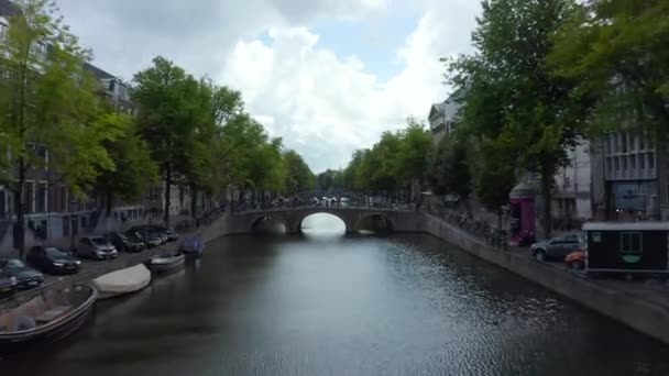 Stabilitore sul canale di Amsterdam con Barca e bandiera olandese sventola nel vento, indietro Aerial — Video Stock