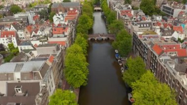 Yeşil Ağaçlı ve Kırmızı Çatılı Amsterdam Kanalı Kanal 'da yavaş yavaş yükseliyor