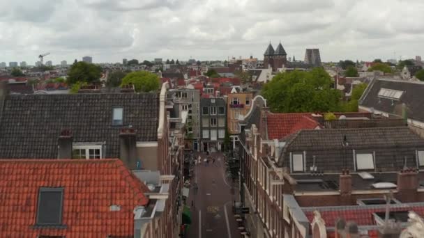 Slow forward Aerial boven typisch Amsterdamse Buurtstraat en Tilt Down on Canal Bridge — Stockvideo