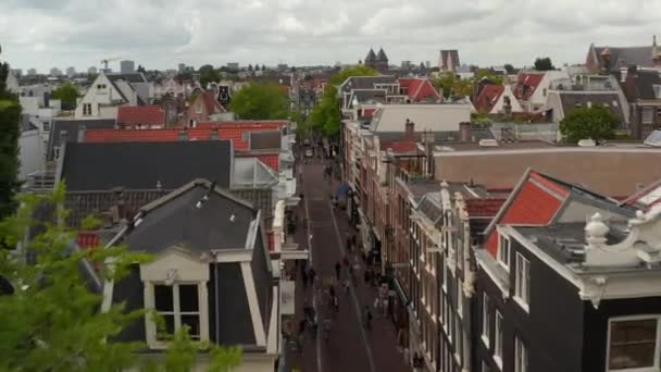 Avance lento Aérea sobre la típica calle Amsterdam con gente comprando — Vídeos de Stock