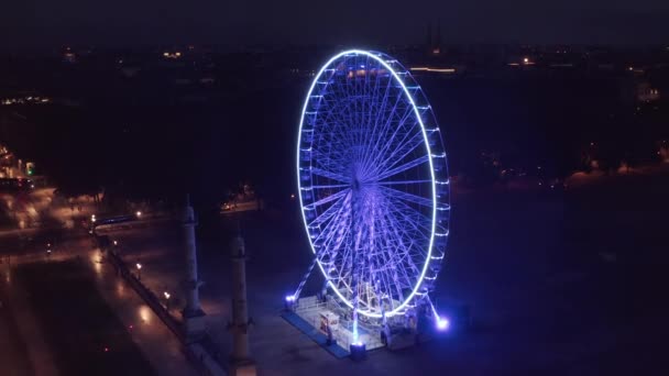 Порожнє колесо Ферріса на площі вночі без людей і блакитне світло з повітряної перспективи — стокове відео