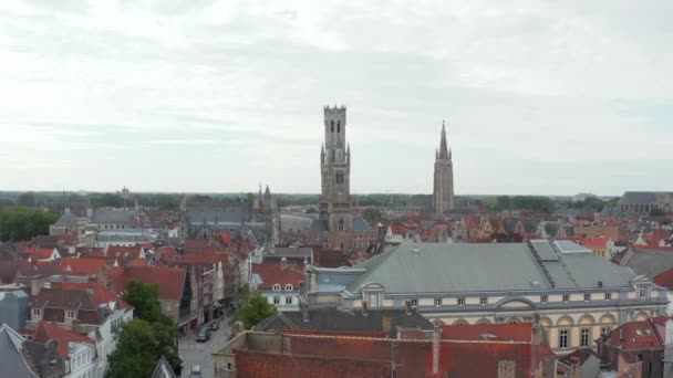 Belfry of Bruges Belltower de uma perspectiva aérea de drones e pombos voando com céu nublado — Vídeo de Stock