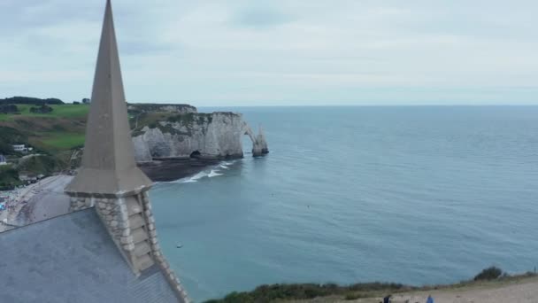 Liten kyrka på kullen, Flyg framåt avslöjar Etretat Cliffs i Frankrike med Overcast Sky — Stockvideo