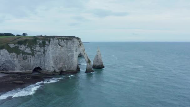 Szerokie ujęcie słynnych klifów Etretat z falami oceanicznymi w dzień zachmurzenia, naprzód z powietrza — Wideo stockowe