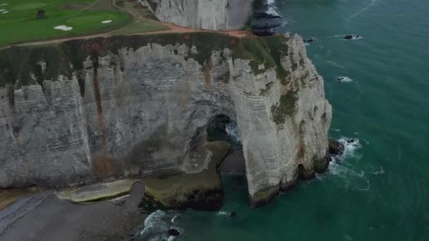 Impresionante Inclinación hacia abajo en el arco del acantilado de Etretat con la gente caminando sobre el borde empinado del acantilado — Vídeos de Stock