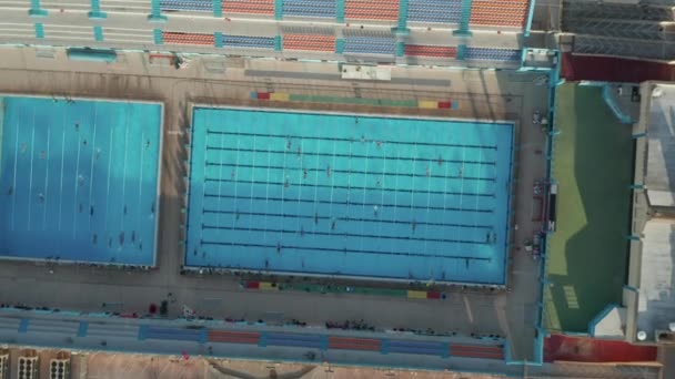 Bella Circling Aerial over Blue Piscina con nuotatori che fanno giri e formazione — Video Stock