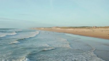 İnsanlar Kaliforniya 'da kumsalda eğleniyor. Güzel bir öğleden sonra ışığı altında. Havadan yüksek açı yavaş dönüyor.