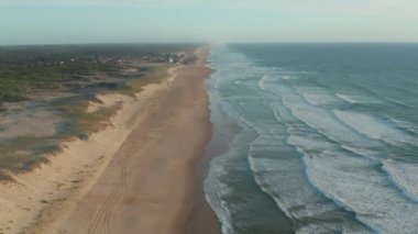 Gün batımında Fransa 'da küçük bir sahil kasabası olan Lacanau ile uçsuz bucaksız kıyı şeridi.