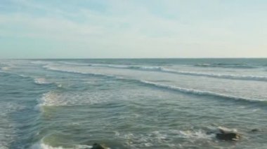 Okyanusta sörfçü, öğleden sonra beyaz köpüklü dalgalar ve berrak gökyüzü, gökyüzü, gökyüzü yüksek açılı ileriye dönük doli