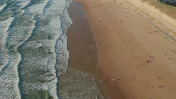 Nur wenige Menschen genießen die Zeit am Strand in Frankreich bei Sonnenuntergang in der goldenen Stunde, im Tiefflug langsam im Kreis — Stockvideo