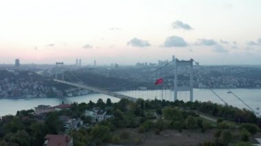 İstanbul Boğazı önünde Türk Bayrağı Dalgalanıyor ve Şehir Güzel Gün Batımında Gökyüzü Sağa Kayıyor